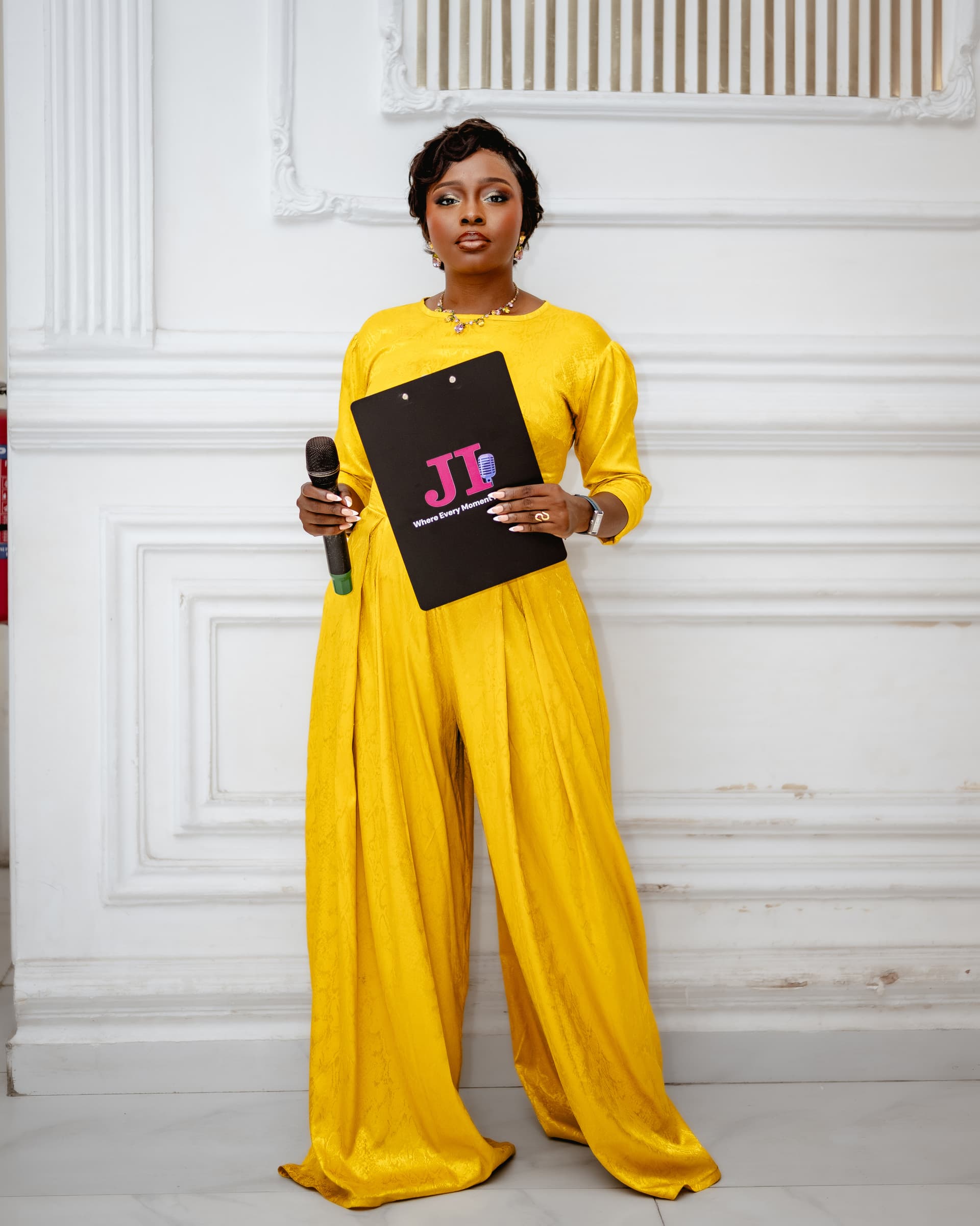 Jennifer Ibrahim hosting with clipboard and microphone