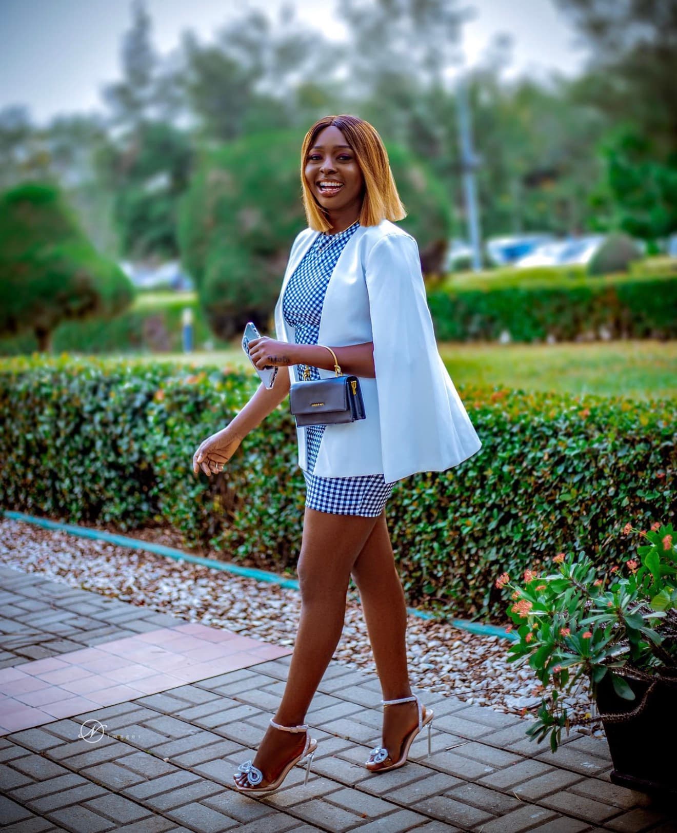 Jennifer Ibrahim outdoors in a white cape blazer