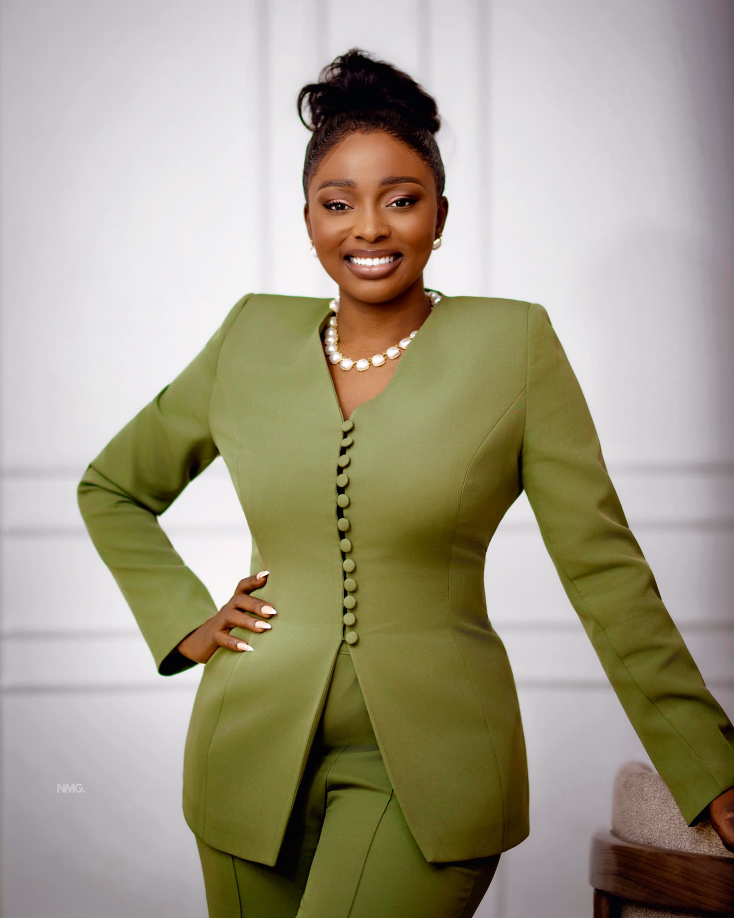 Jennifer Ibrahim smiling in an olive suit